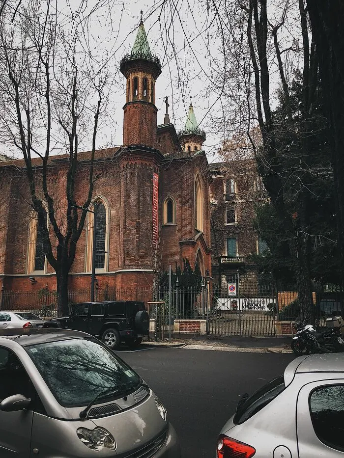 An old brick building with towers and bare trees, a setting where wild coincidences might occur.