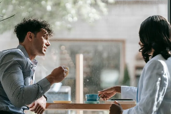 Two people talking in a cafe, discussing mens turn-offs.