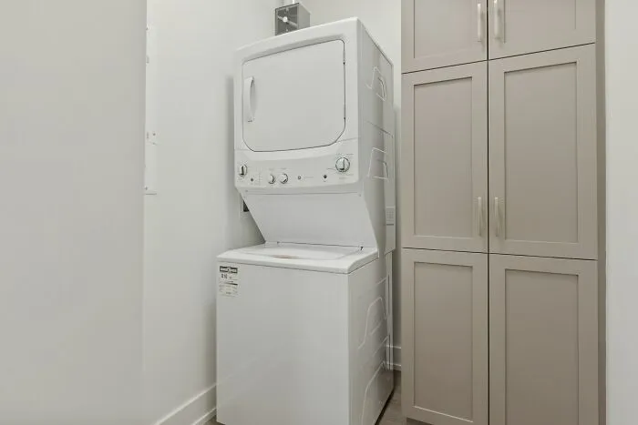A white stacked washer and dryer unit in a small laundry room, an ordinary scene that can feel creepy.
