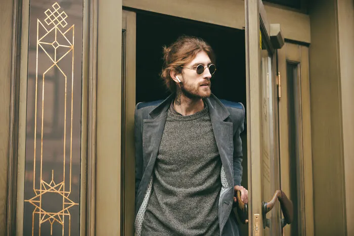 Man in glasses and coat exiting building symbolizing meeting a psychopath