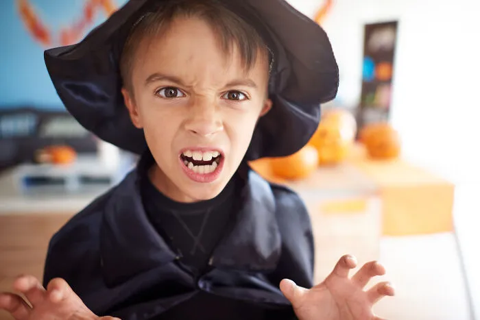 Primary child dressed as a witch showing intense psychopathic behavior expression
