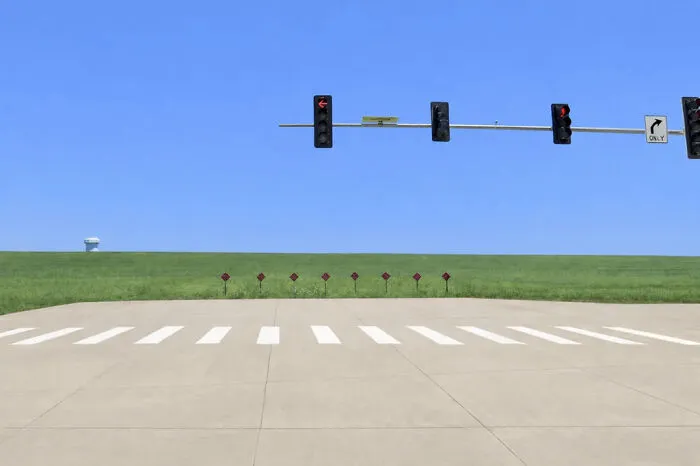 Traffic lights over an empty rural road with a clear horizon create an unsettling liminal space. The scene descends into the abyss.
