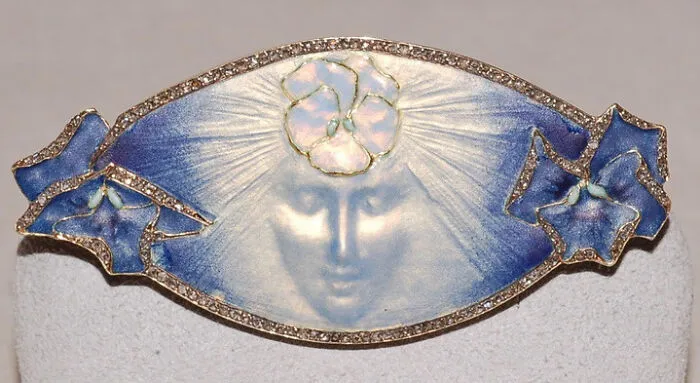 Art Nouveau brooch featuring a delicate face and blue enamel, an interesting object still intact.