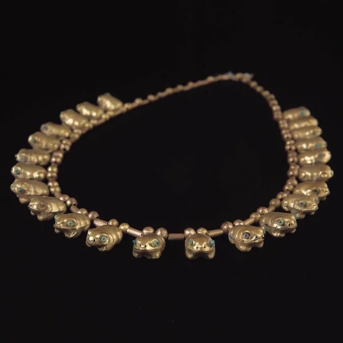 Gold necklace with frog-shaped beads and turquoise eyes, an interesting object still intact after all these years.
