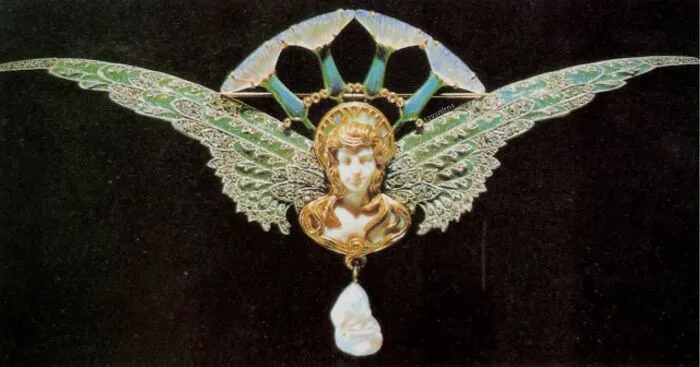 Elaborate Art Nouveau brooch featuring a winged figure and pearl drop, an intact object of beauty.