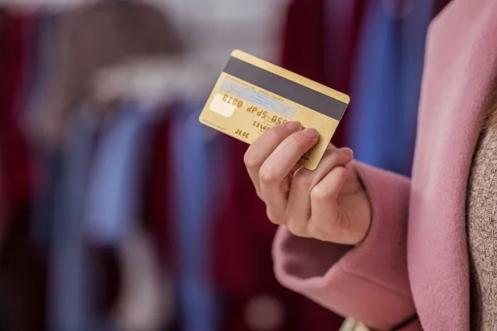 Person holding credit card in hand inside store