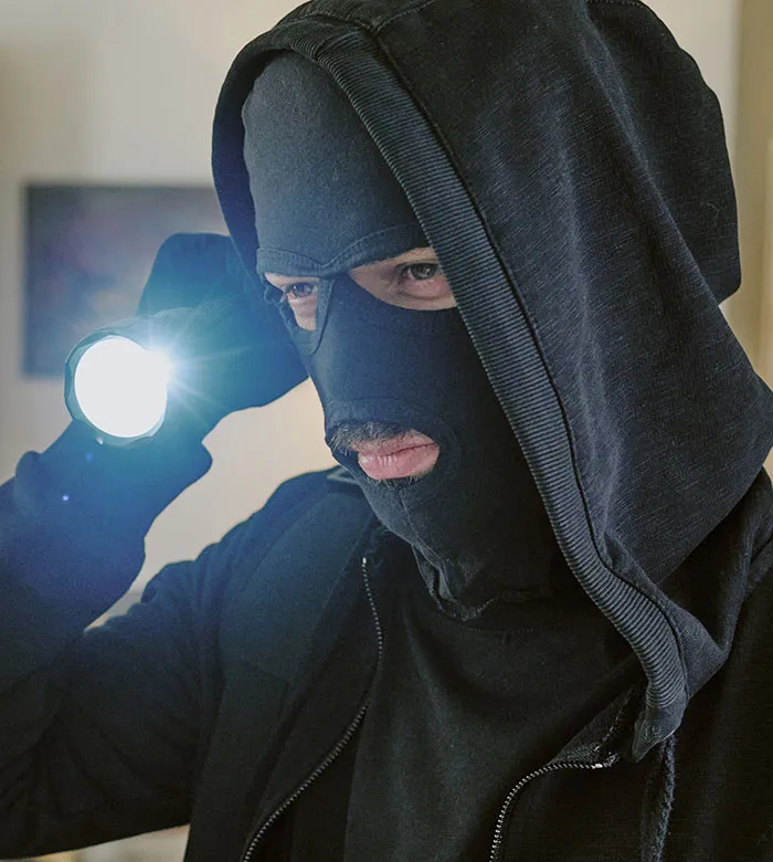 Hooded man with mask and flashlight illustrating smooth criminals