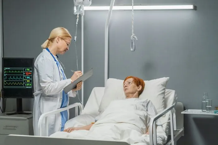 Doctor talking to patient in hospital room with monitor