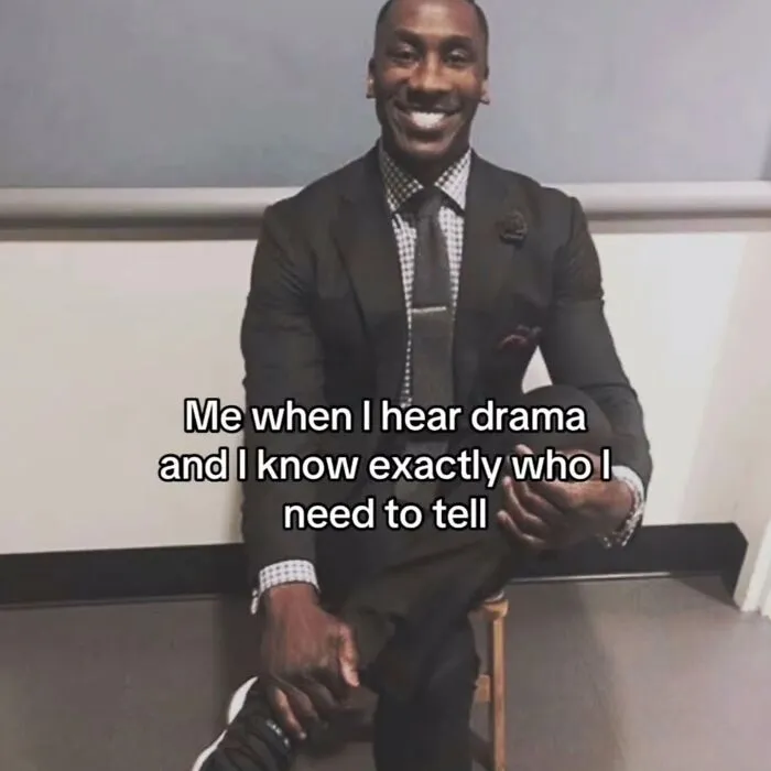 A man in a suit, smiling, with the caption: Me when I hear drama and I know exactly who I need to tell. Relatable meme.