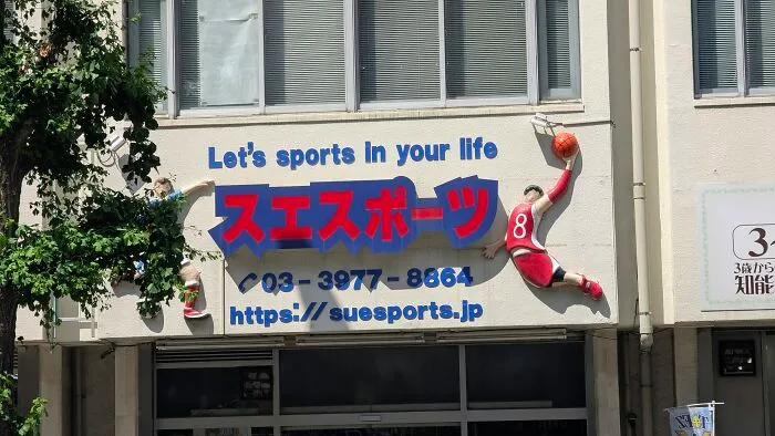 The facade of a sports building in Japan with the phrase Let's sports in your life, a hilarious example of getting lost in translation.