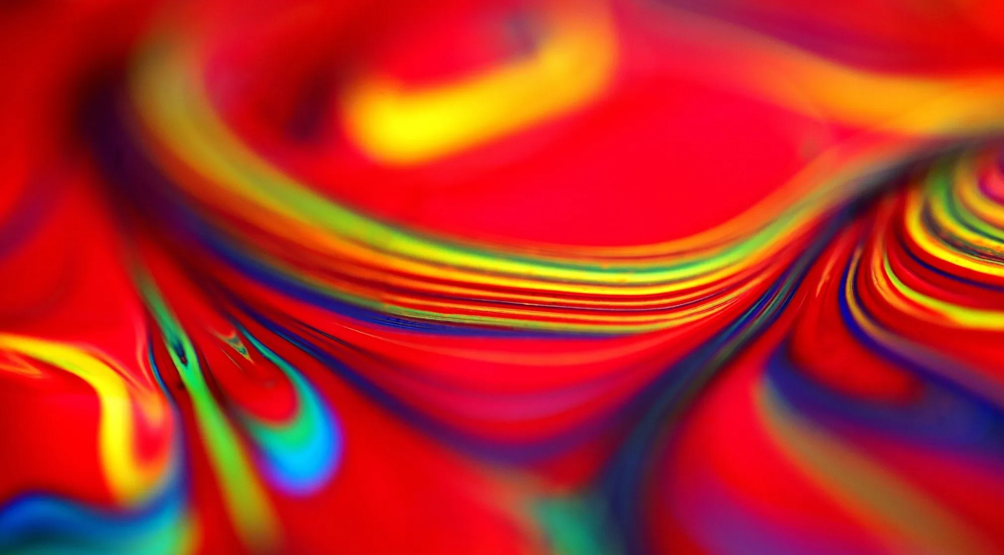 Vibrant abstract art with swirling lines of yellow, green, and blue on a dominant red background, suggesting something brilliant.