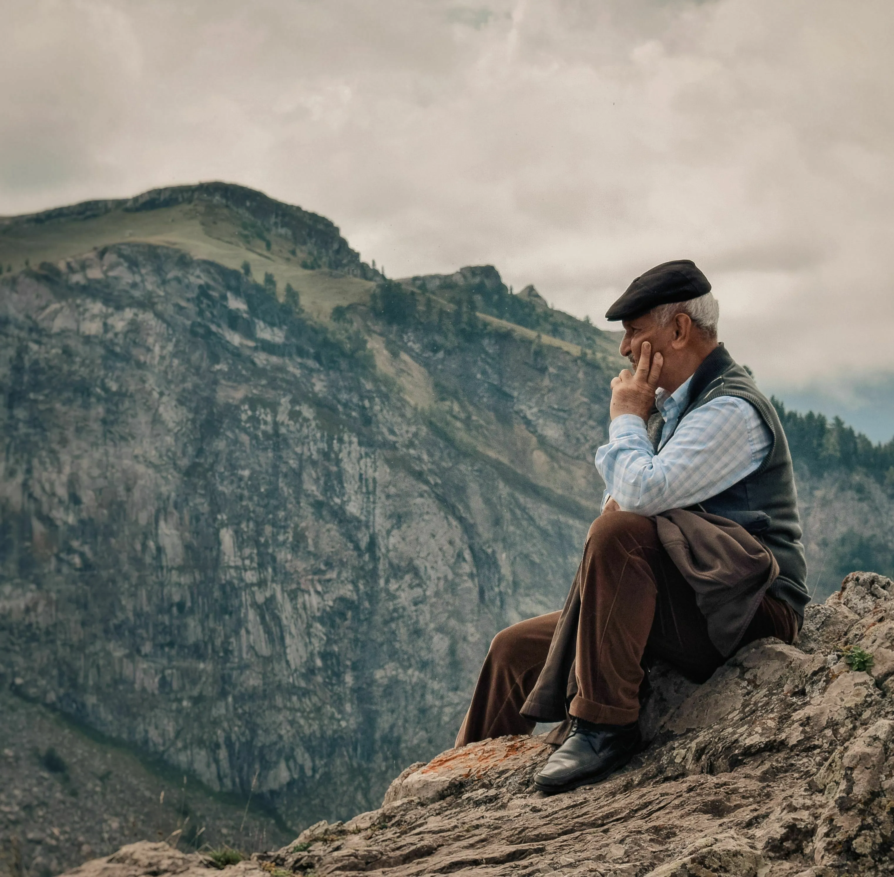 An old man sits on a mountain contemplating ancient Greek concepts, like the pursuit of a flourishing, well-lived life, or eudaimonia.