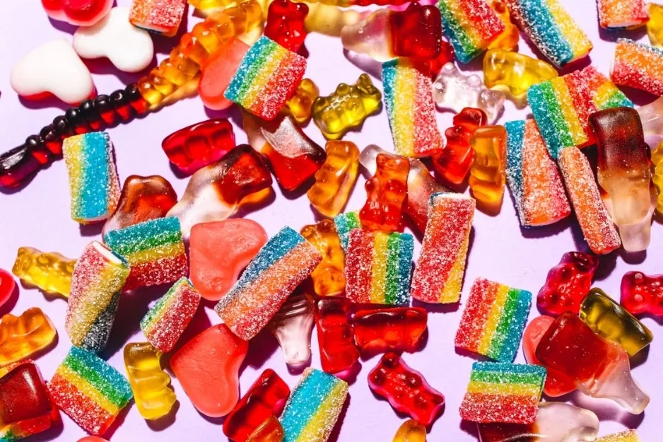 A colorful assortment of gummies, including rainbow strips and various shapes, a fun snack for a road trip.