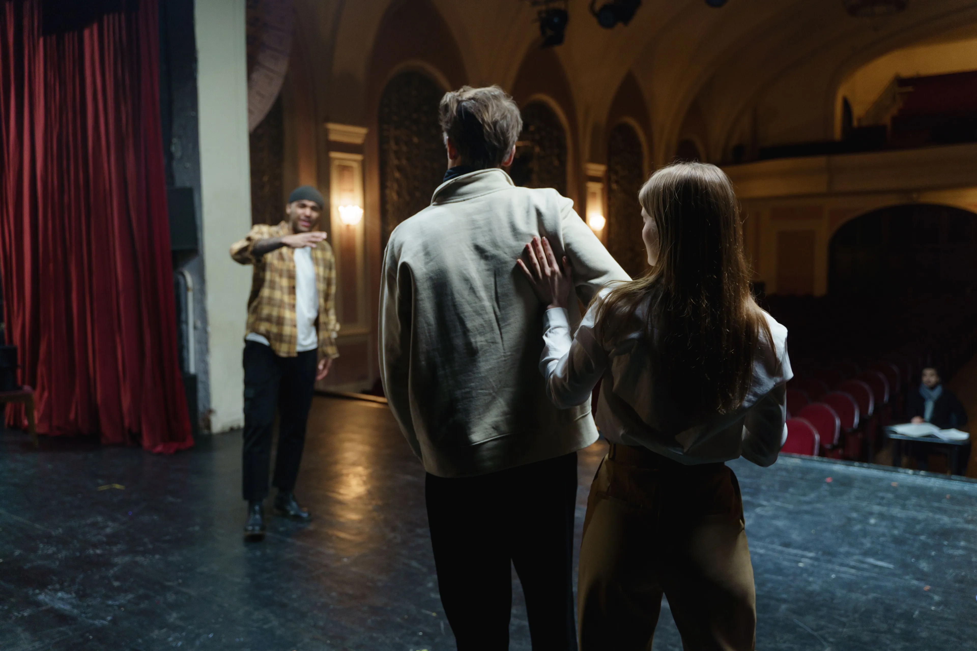 Actors rehearsing on a dimly lit stage, highlighting the school subject of Drama.