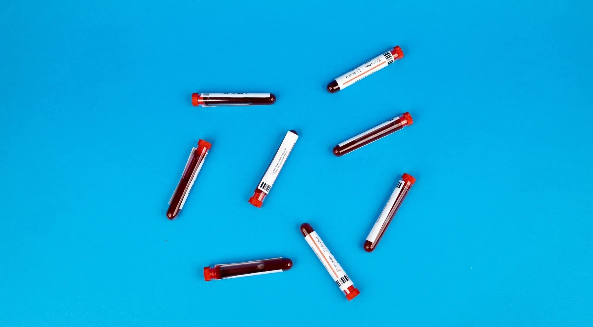 Test tubes filled with blood on a blue background, related to the human body and universal donor blood type.