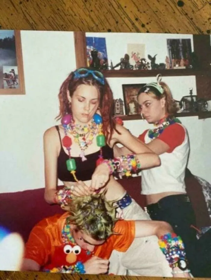Three 90s kids with neon hair and plastic jewelry, captured in a throwback meme.