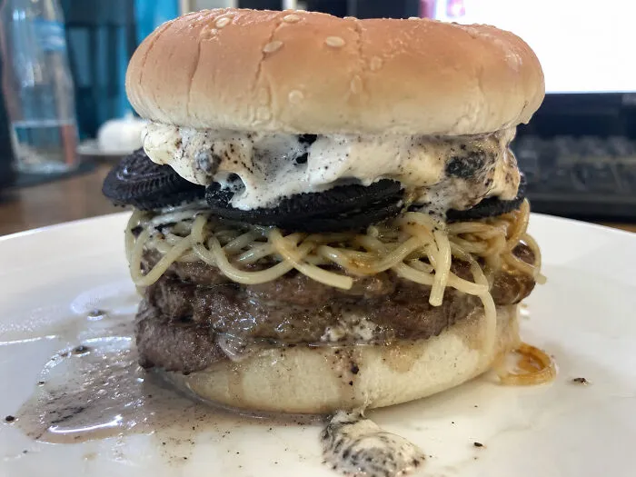 A strange burger filled with cookies, ice cream, and noodles as a questionable food combo.