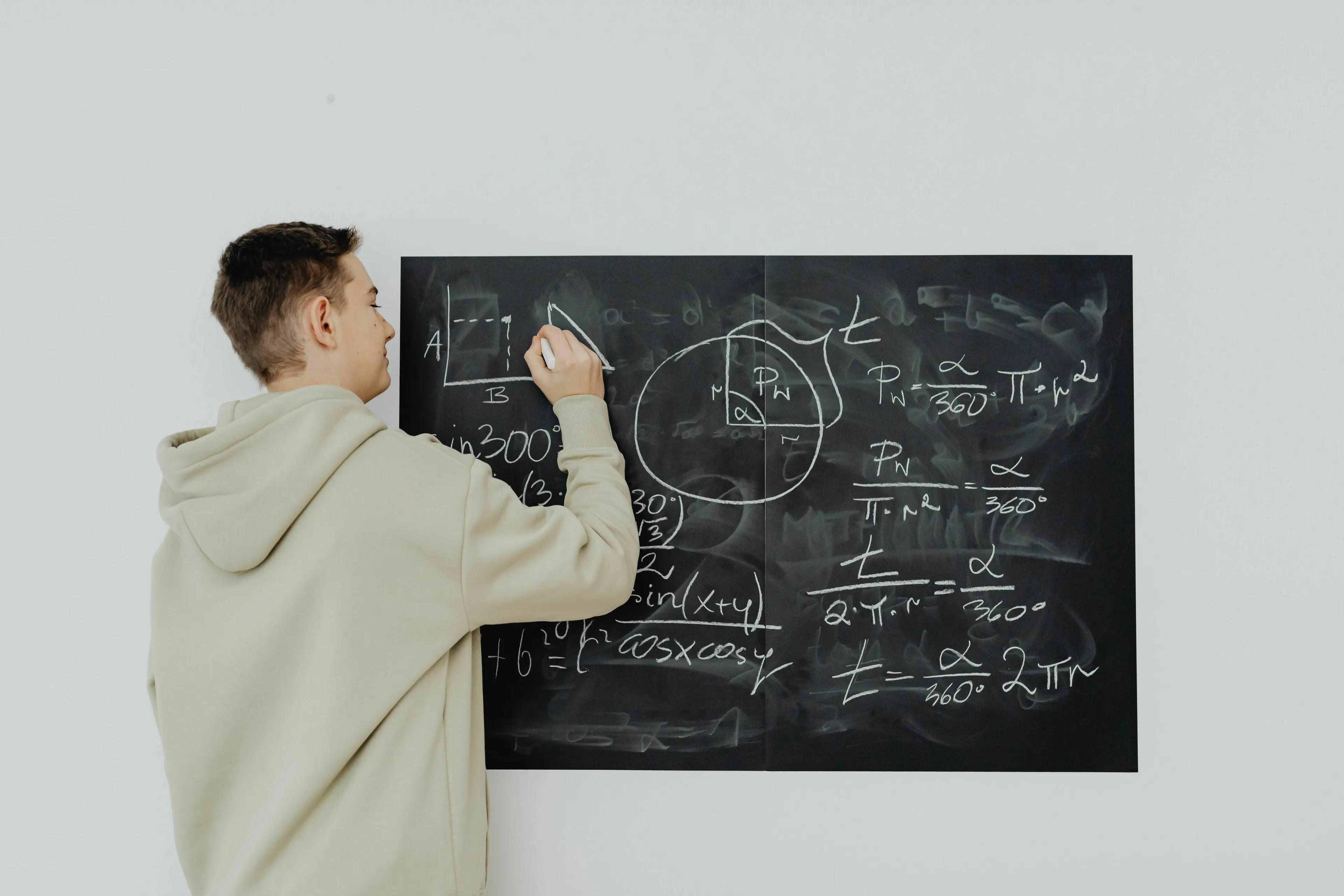 Student writing math formulas on a blackboard, a visual for a general knowledge quiz about numbers.