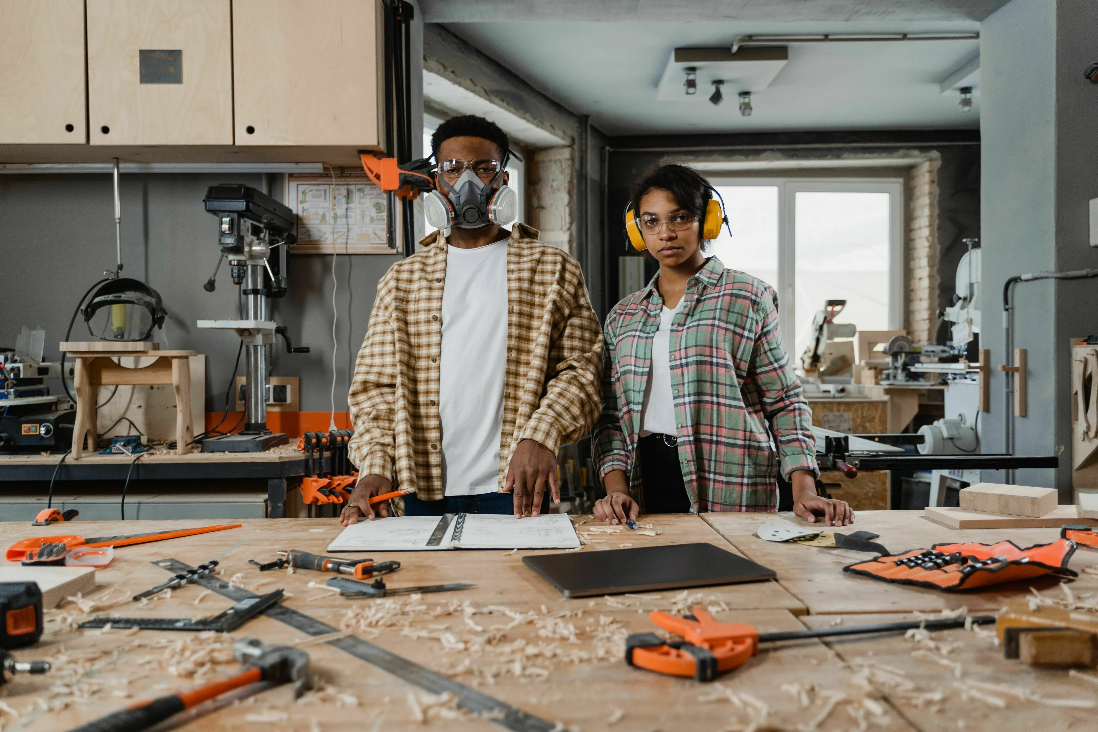 Two people in a workshop, wearing safety gear. They are ready for home projects. The DIY trend has exploded.