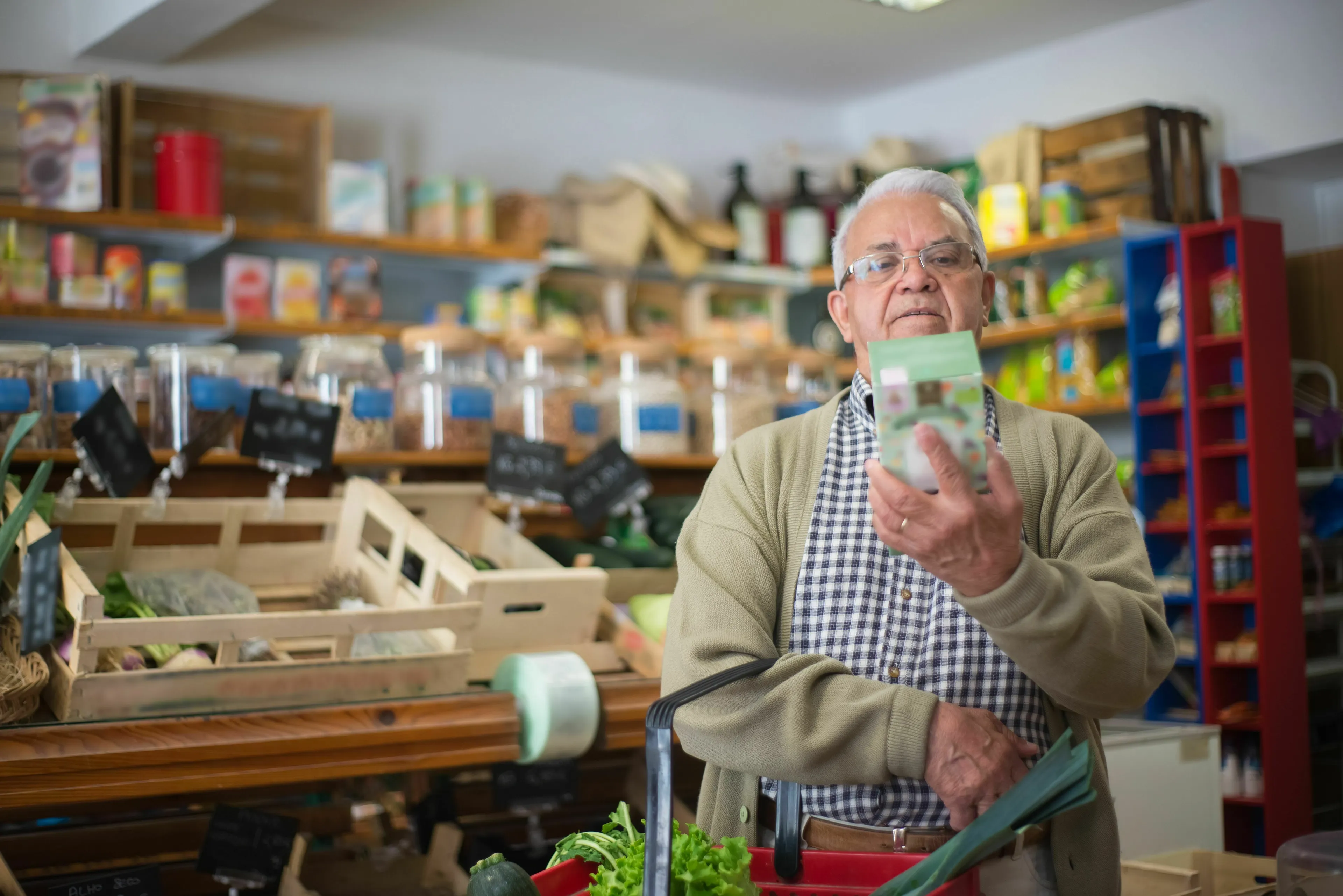 A senior man scrutinizing a food ingredients label, contemplating conspiracy theories about food.