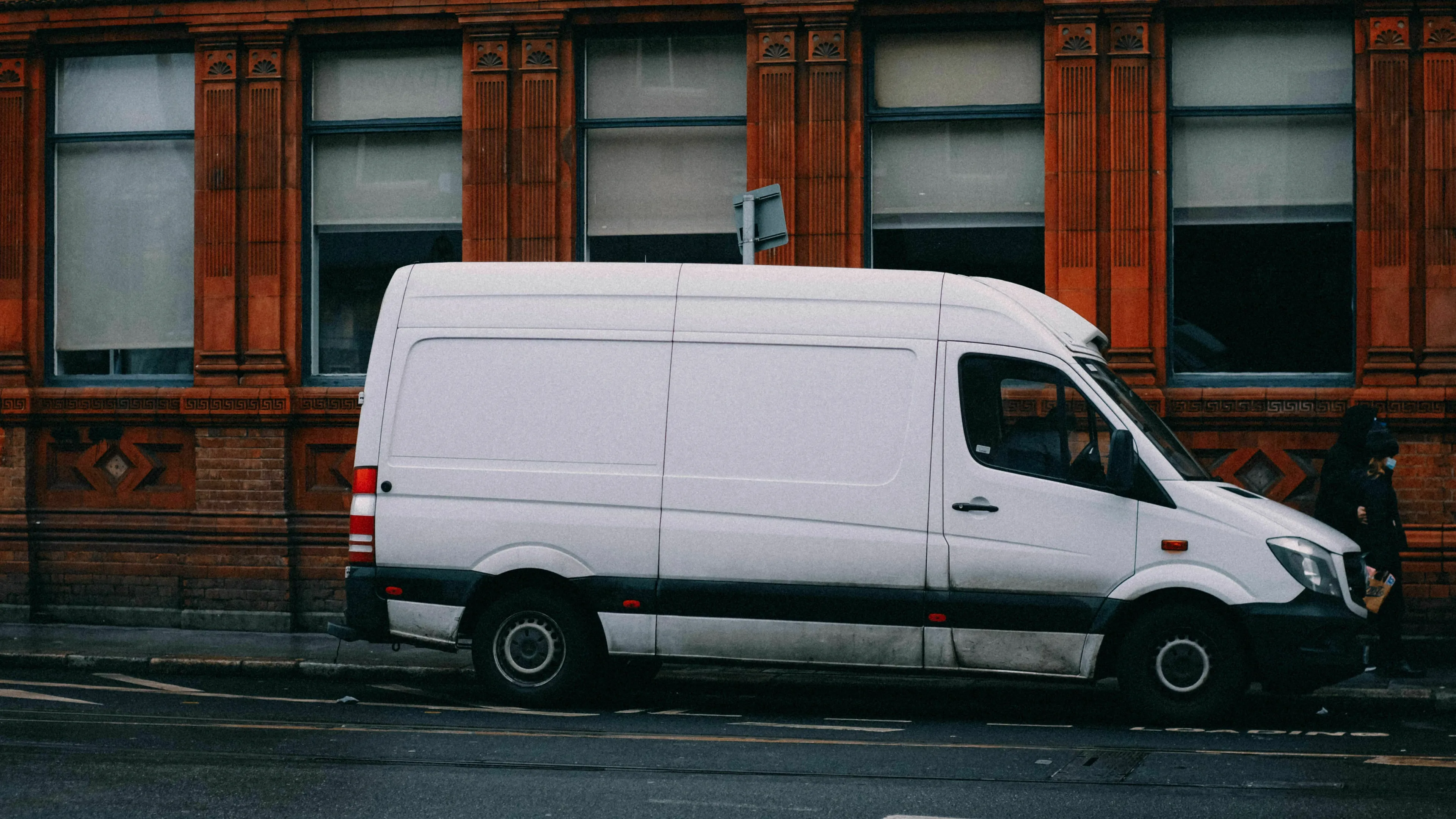 A white van parked on a street next to a building, prompting questions about a white van sighting.