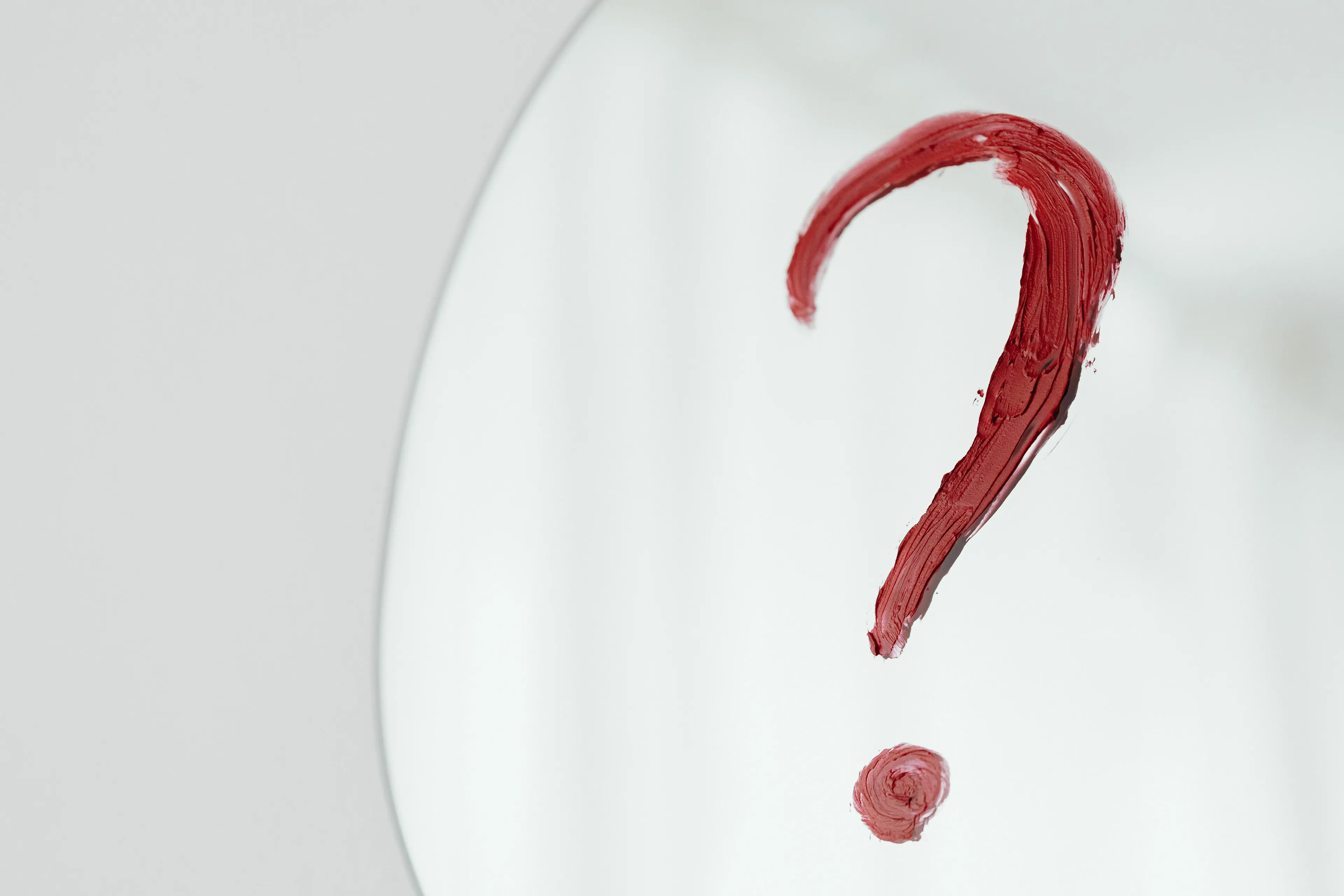Conspiracy theory personality quiz: A red question mark drawn on a mirror, representing coincidences.