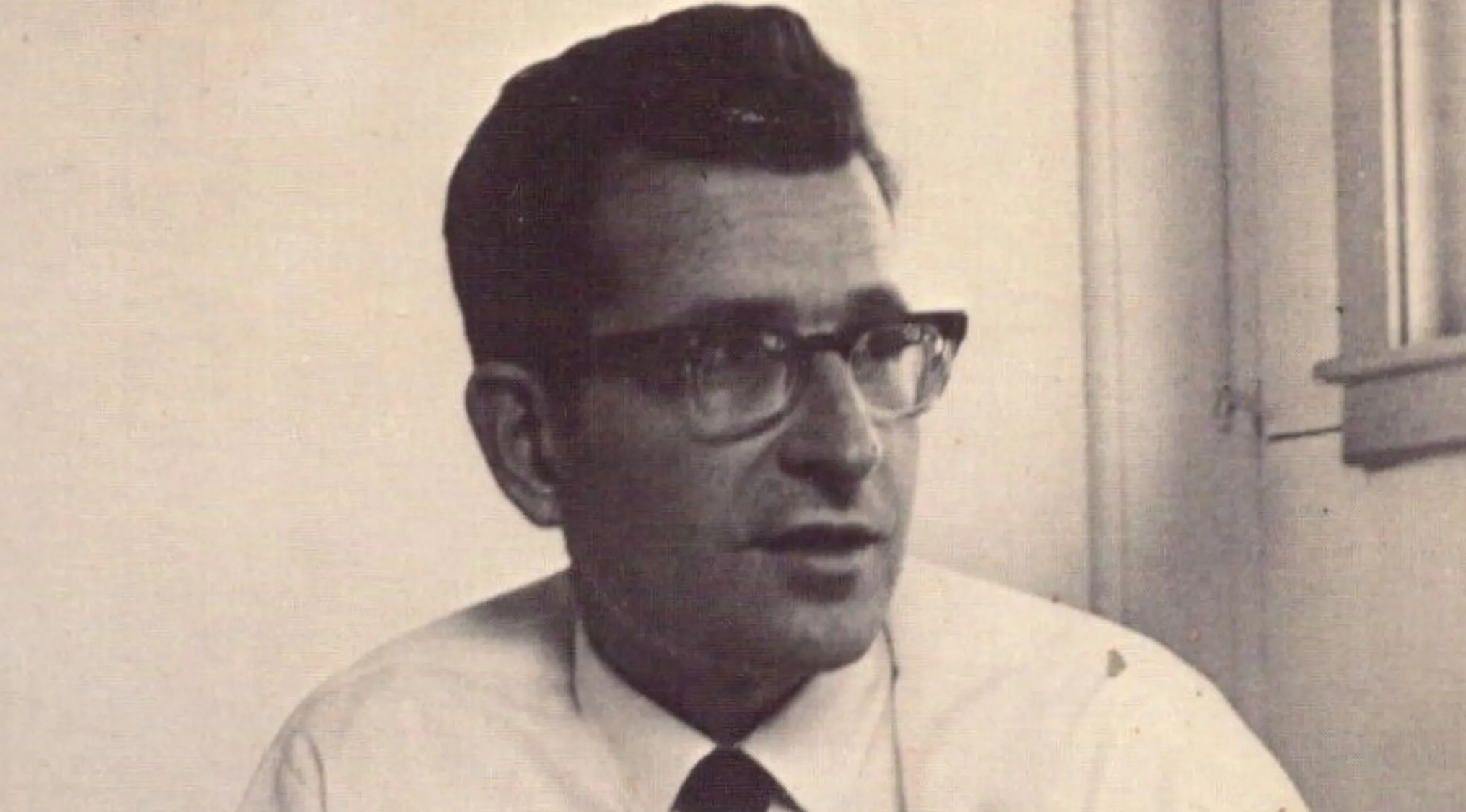 A black and white photo of Noam Chomsky, a linguist and political activist, wearing glasses.