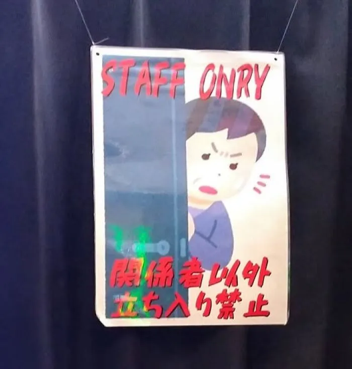 A hand-drawn sign in Japan says 'STAFF ONRY' (only) with an angry cartoon face, an example of getting lost in translation.