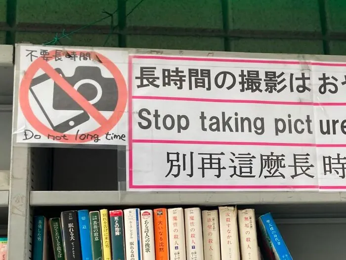 A sign in Japan saying 'Stop taking picture' and 'Do not long time' with a camera crossed out, a hilarious example of lost in translation.