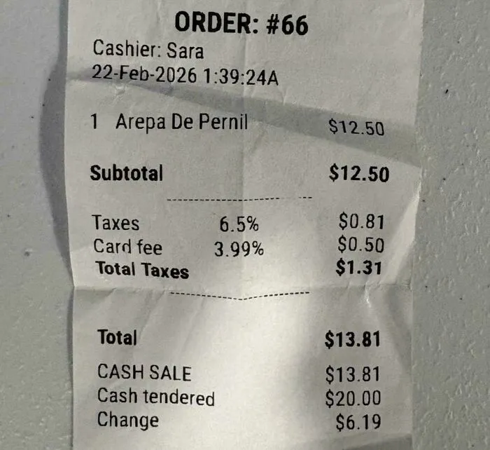 A receipt showing a card fee, illustrating the additional costs in transactions beyond tipping culture.
