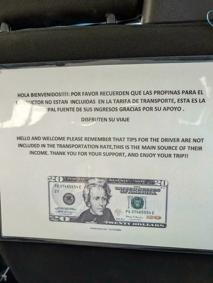 A sign in a vehicle asking for tips for the driver, emphasizing tipping culture in transport services.