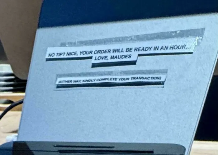 A sign at Maudes implying a long wait if you dont tip, highlighting a facet of tipping culture.