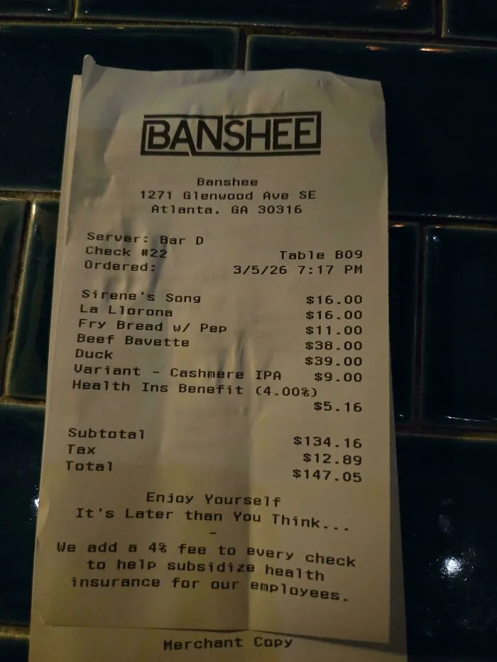 A restaurant bill from Banshee, showing items ordered, prices, and a 4% health insurance benefit fee that aims to end tipping culture.