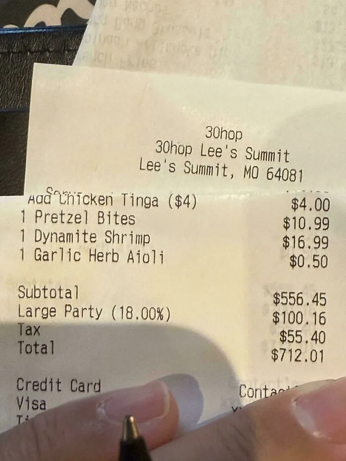 A detailed restaurant receipt showing a large party charge and high total, raising questions about tipping culture.