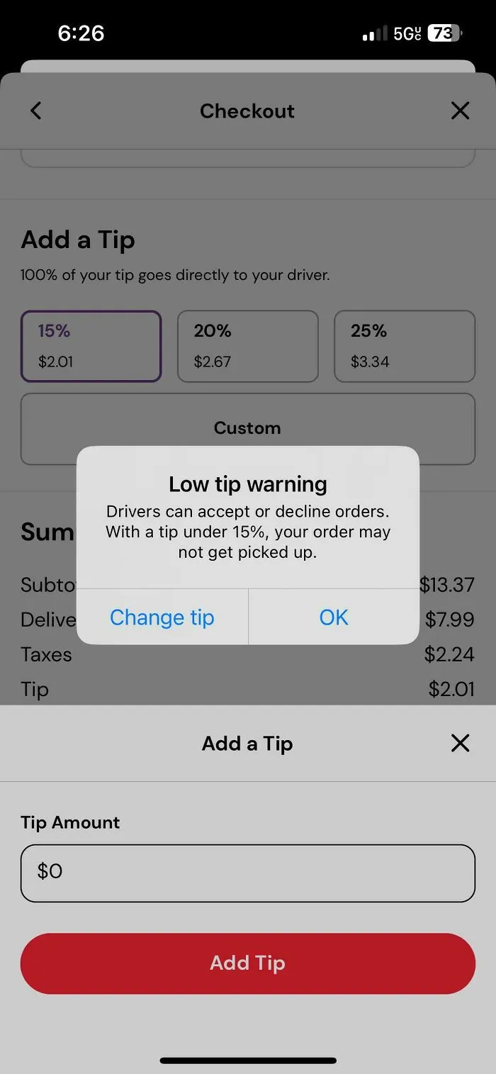 A low tip warning pop-up on a food delivery app, illustrating the ongoing debate on tipping culture in the US.