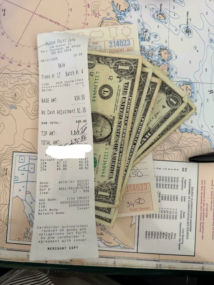Restaurant receipt showing a zero tip amount, next to dollar bills, illustrating a decision to end tipping.