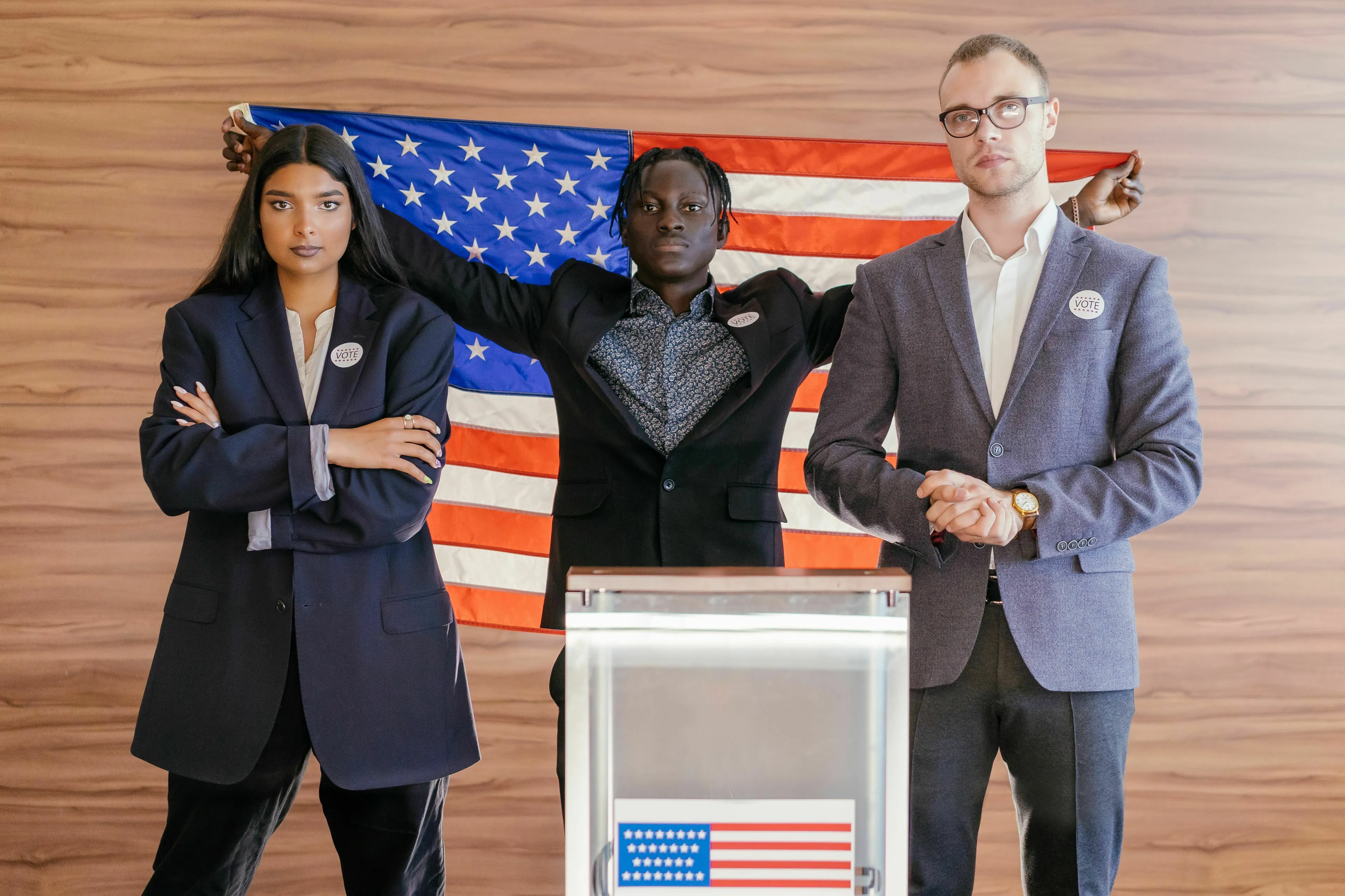 Three diverse individuals stand before an American flag, representing a candidate's poll support and margin of error in Statistics.