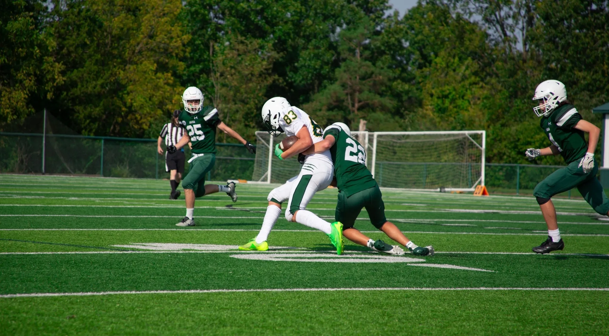 Football players in green and white uniforms in a tackle, a great example of a fishing term with a double meaning.