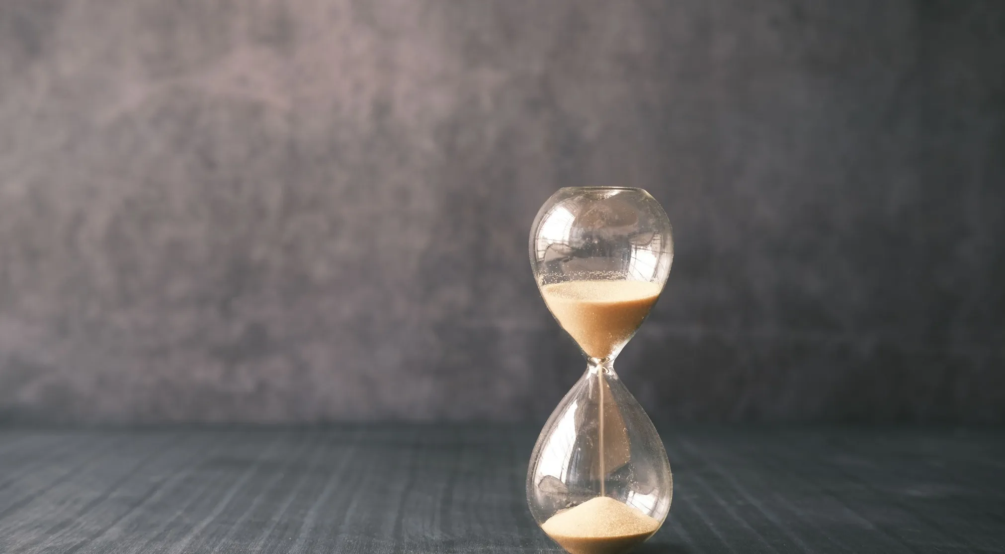 An hourglass with sand flowing through, symbolizing the double-meaning word: 'punch' or 'time' in a temporal sense.