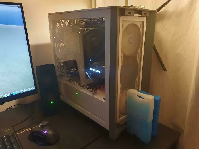 Ice packs placed next to a computer tower, a clever solution for keeping electronics cool.