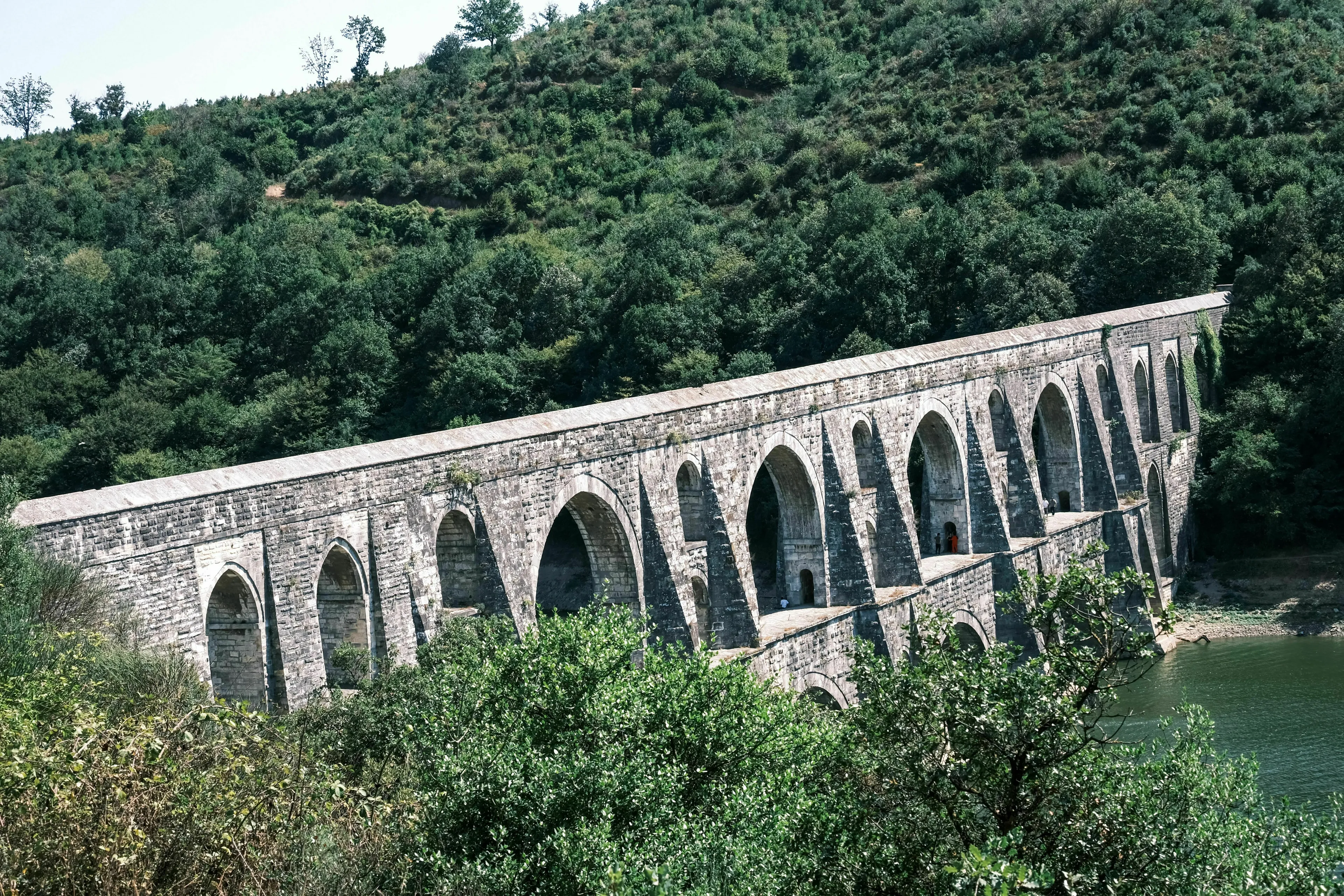 A historical Roman aqueduct stretches across a landscape, highlighting a potential breakdown for an ancient Roman job.