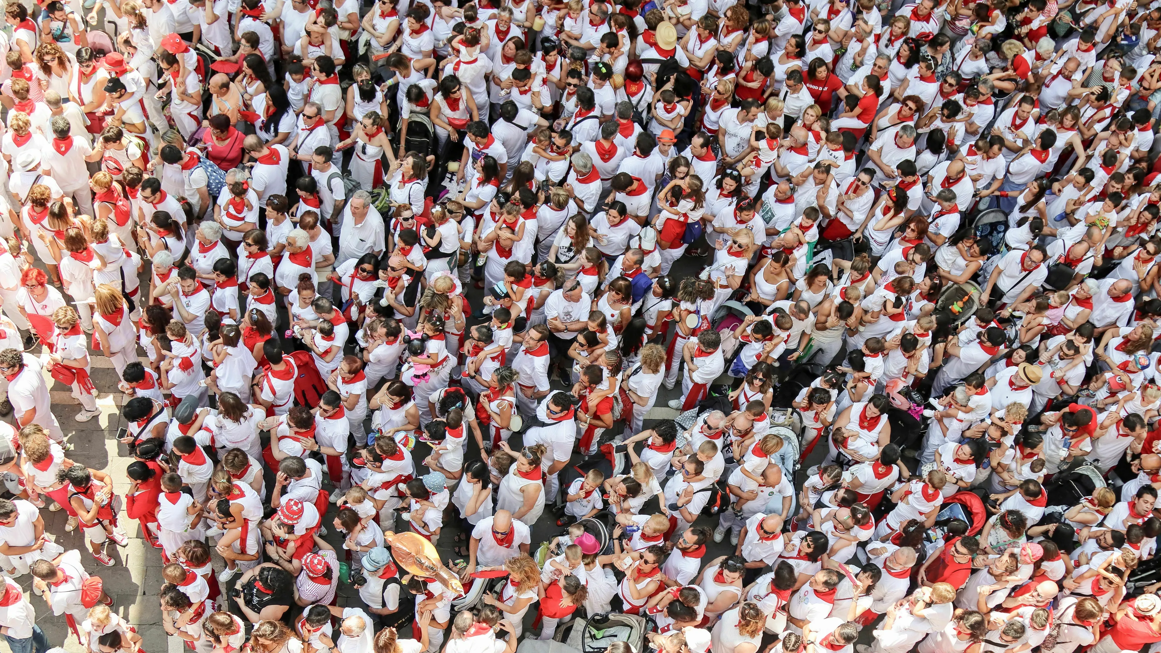 An overhead view of a large crowd of people in white and red, representing a person's relationship with the crowd in ancient Rome.