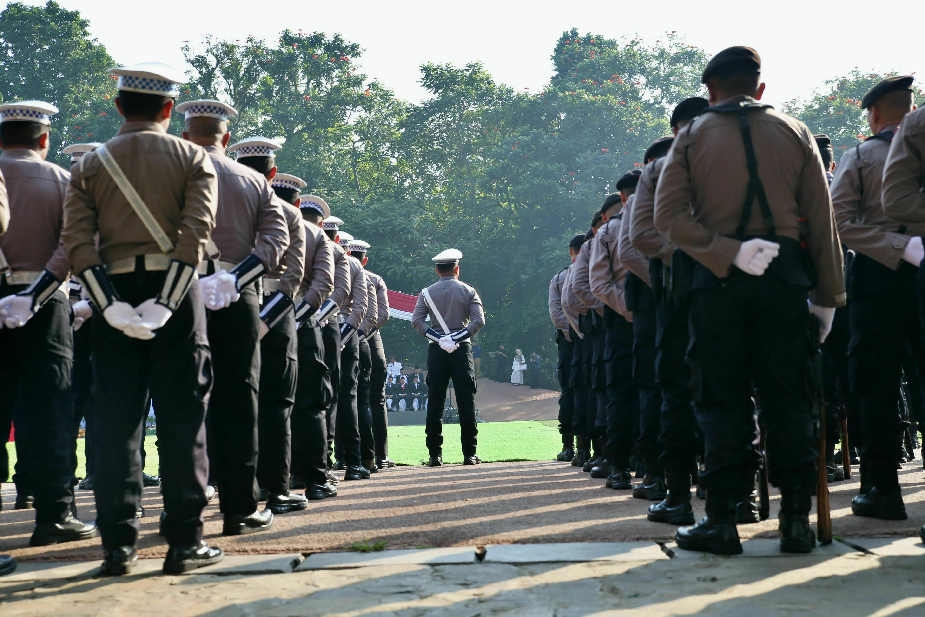A line of uniformed police officers stands in formation, illustrating the concept of taking orders in an ancient Roman job.
