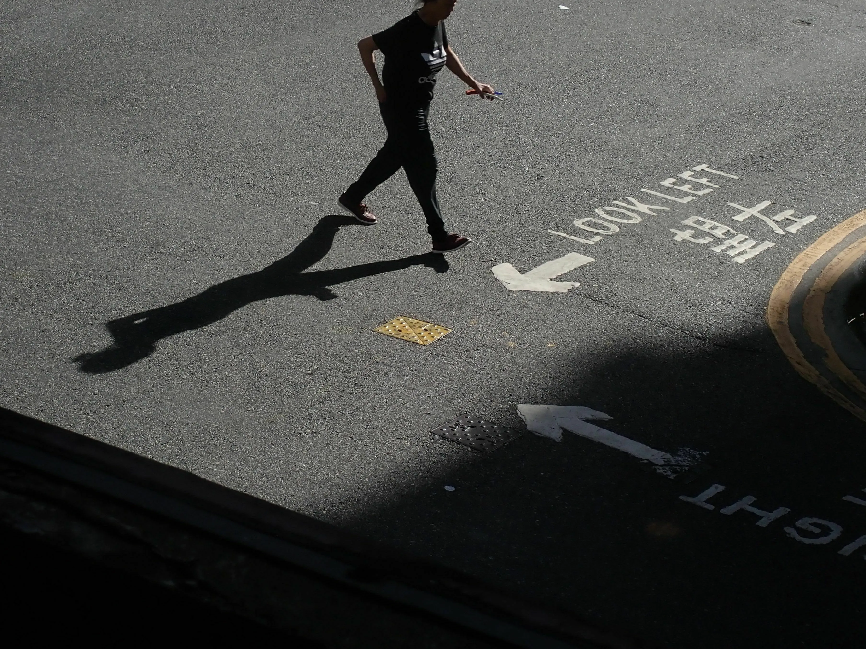 A person walking past painted arrows on the street, depicting a shortcut for getting ahead in Ancient Rome.