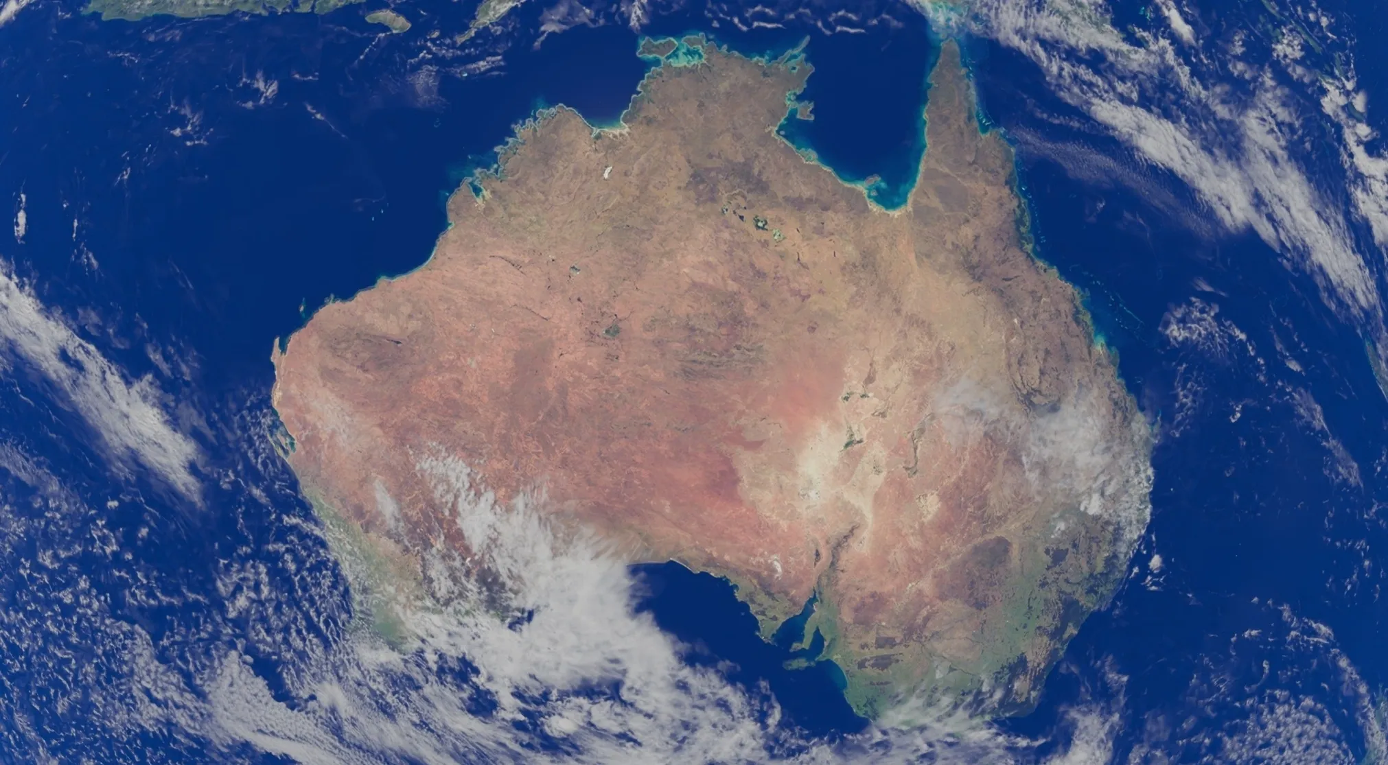 Satellite image showing the continent of Australia from space, highlighting its vastness and the surrounding ocean. Australia is wider than many expect.