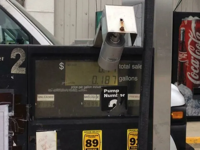 Wild and unhinged way to fix a broken gas pump with a security camera dangling from the top.