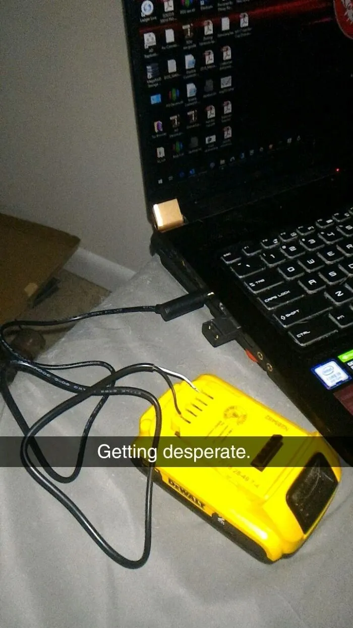 A laptop being charged by a Dewalt battery, an unhinged way to fix something.