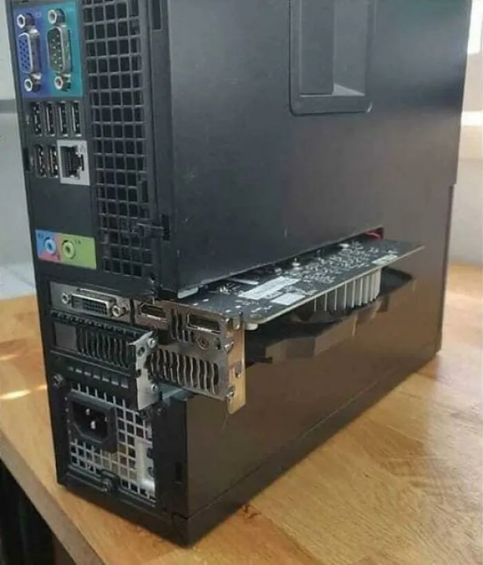 A computer case with a graphics card unhinged and sticking out, demonstrating a wild way to fix something.