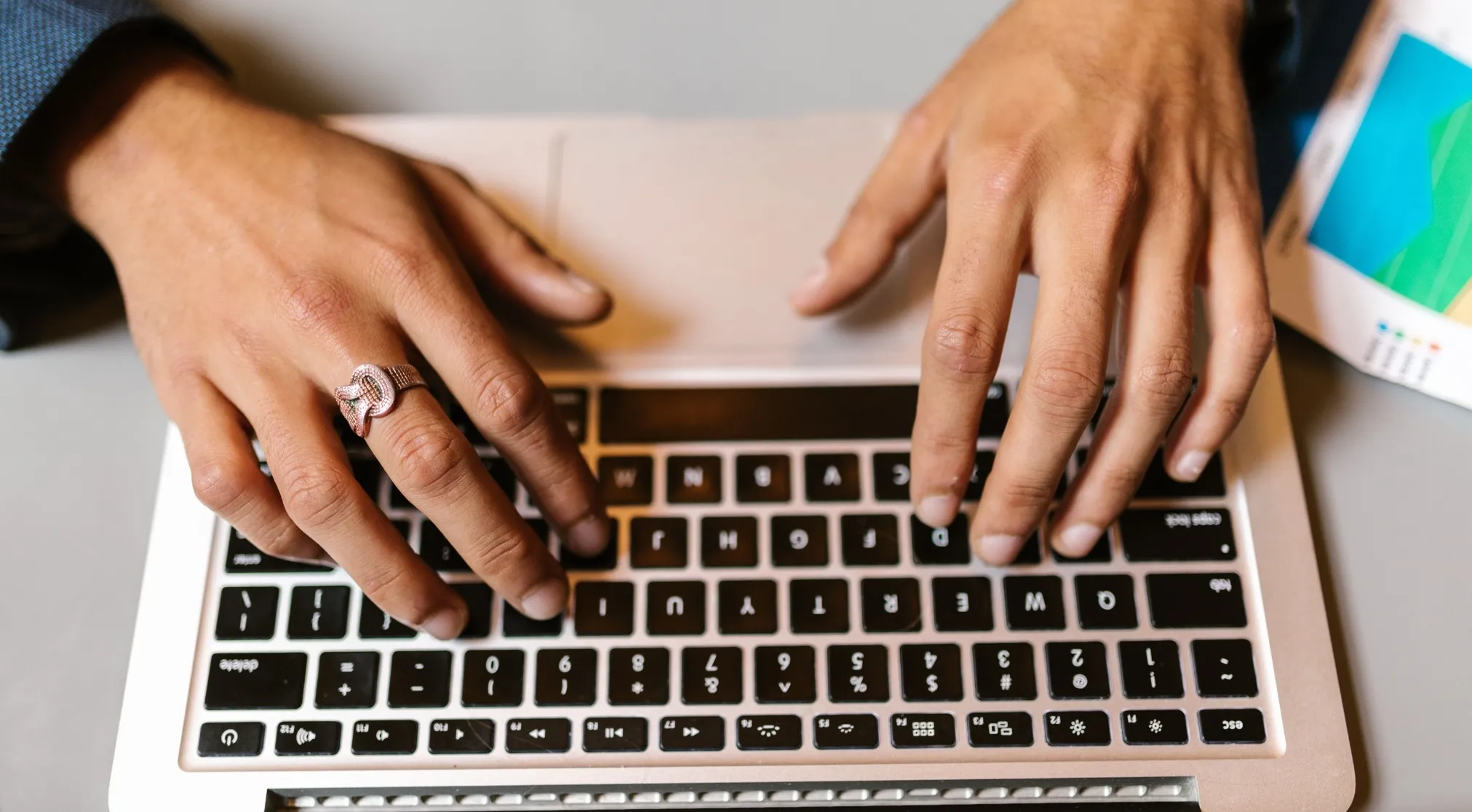 Hands typing on a laptop keyboard. An informal email closing is discussed, alongside Chinese exam language.