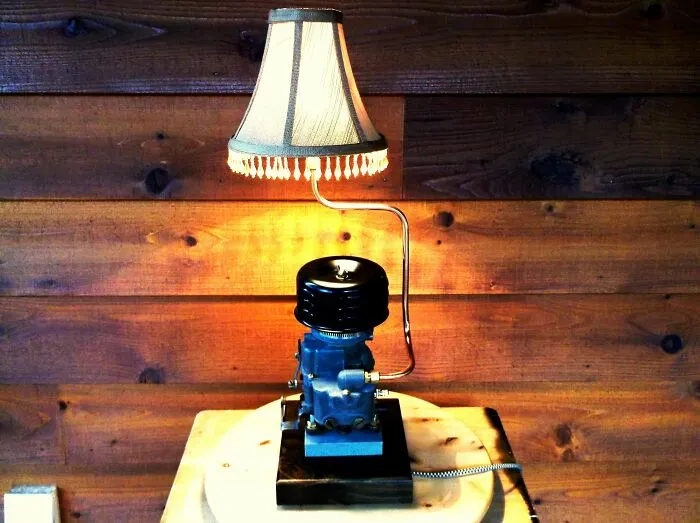 A unique table lamp crafted from an old engine part, showcasing creativity turning old junk into decor.